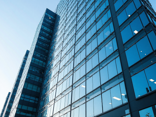 现代化办公楼外观，玻璃幕墙建筑，蓝天白云背景，企业标识清晰可见